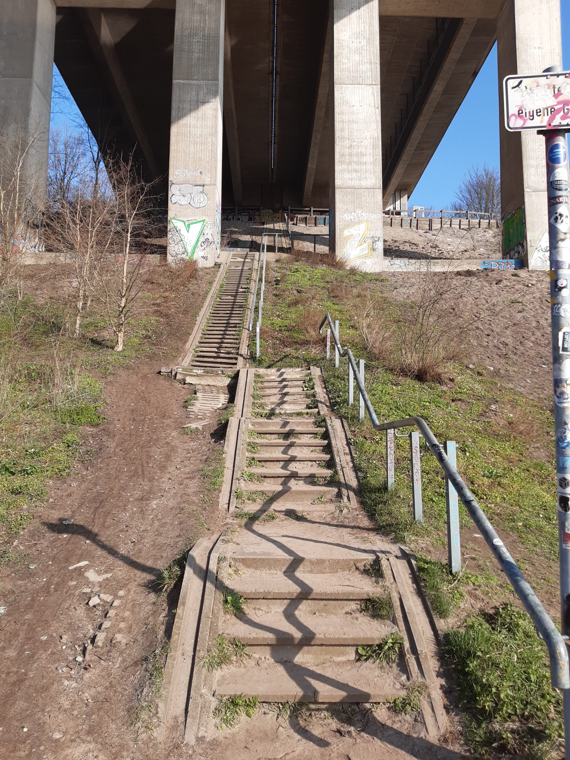 Foto Aufgang der Huntebrücke in Oldenburg, viele Stufen führen zwischen den Pfeilern hoch zum Übergang